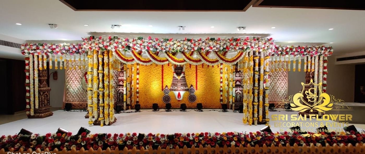 Yellow and white jasmine wedding mandap with ornate traditional pillars