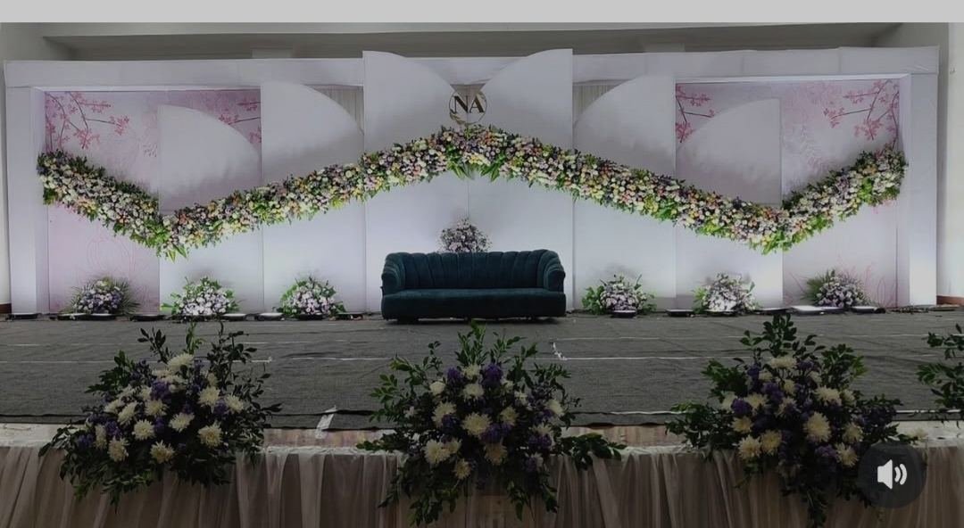 Elegant wedding reception stage with teal sofa and pink floral panel accents